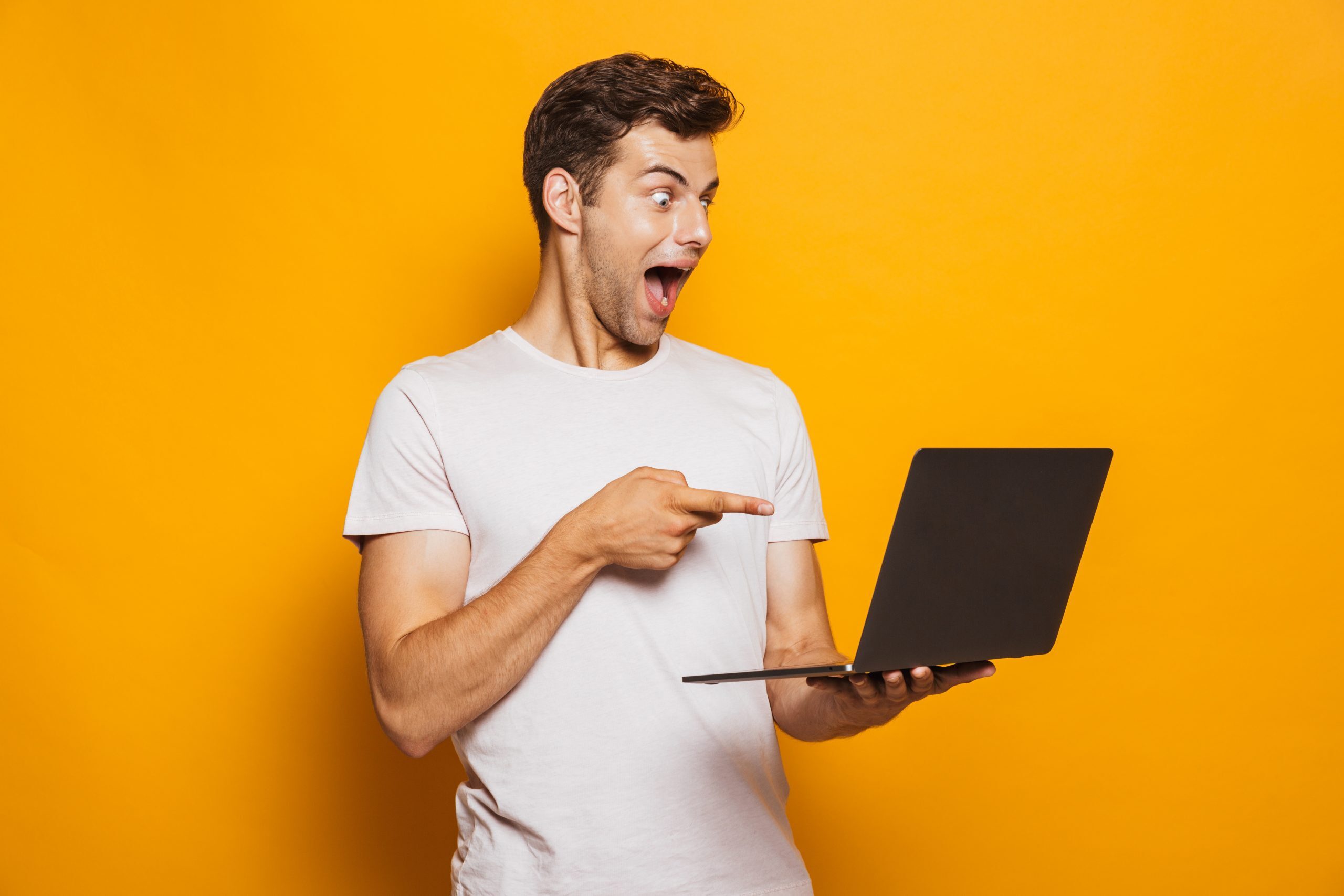 cropped-AdobeStock_Young-guy-holding-laptop-and-pointing-at-it-scaled-1.jpeg